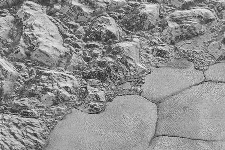 The informally named al-Idrisi mountains meet the smooth surface of Sputnik Planum in this image.