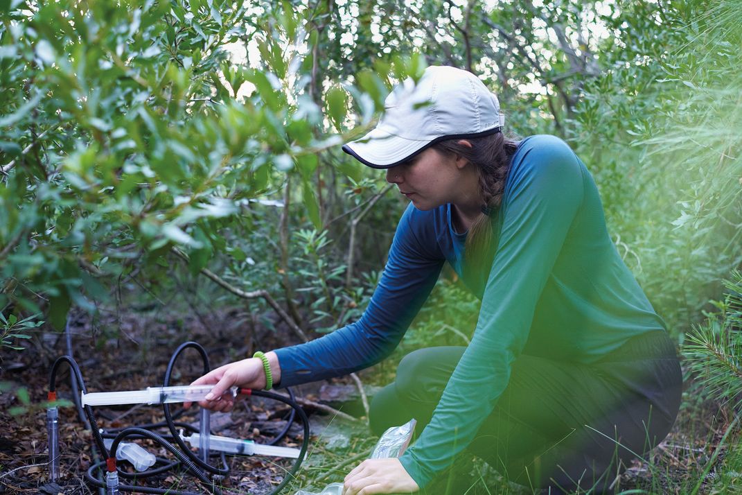 a women in white cap crouches to collect information