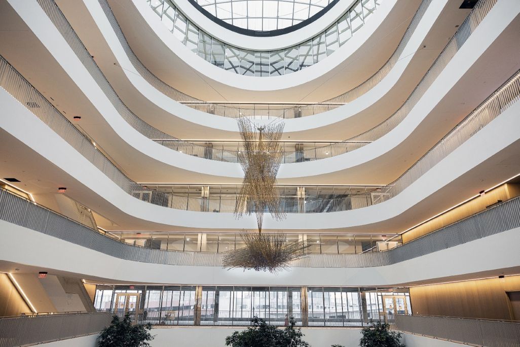 A large atrium with a work of art hanging from the middle