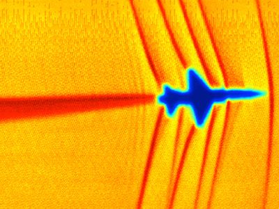At Mach 1, shock waves coming off a T-38 (seen using Schlieren photography) will coalesce to form a mighty boom. 
