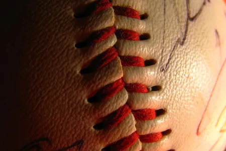 Players&rsquo; signatures are blurred as the red threading of this baseball comes into focus.

