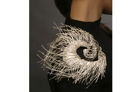 The spiraled crafted work&nbsp;On the Air&nbsp;by Jeong Ju Lee is made to&nbsp;flow with the contour of the model&#39;s shoulder.