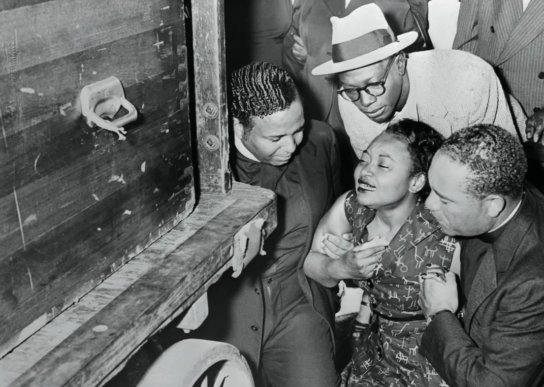 Mamie Till-Mobley weeps as the body of her murdered 14-year-old son, Emmett Louis Till, arrives at a Chicago train station.