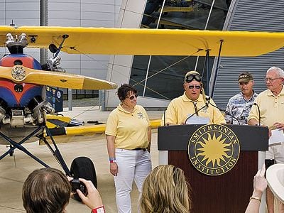 An emotional Gene Breiner (at lectern, with daughter Joyce and General Jack Dailey, director of the National Air and Space Museum) donated Plane Jane to the Museum this past June in hopes of inspiring future pilots.