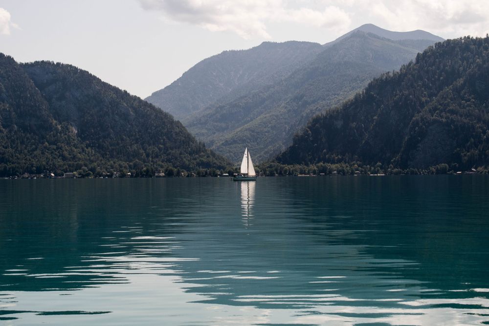 Touring the Attersee in Austria and saw this single sailboat at the base of two mountains.