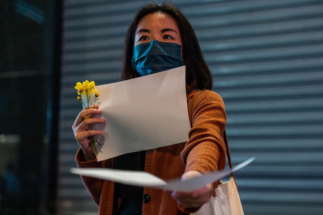 A protester hands out blank pieces of paper during a demonstration in Hong Kong on November 28.