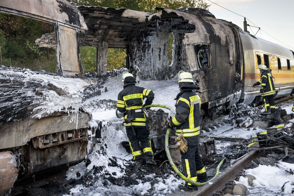 Firefighters use foam to extinguish a fire on a train car