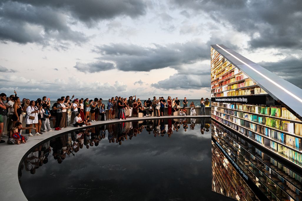 People look at Library of Us, an installation by British artist Es Devlin, during Miami Art Week. The 50-foot-wide rotating triangular bookshelf contains 2,500 books that have shaped the artist's life and practice.