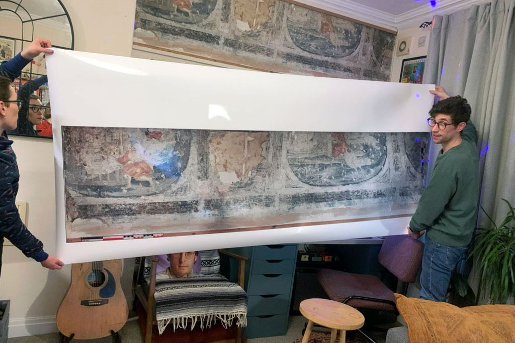 Luke Budworth holds replica of mural