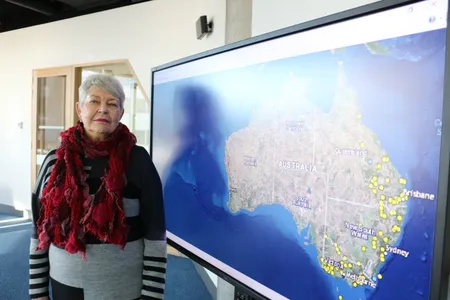 Professor Lyndal Ryan poses with the online map of colonial Frontier massacres in Eastern Australia. 